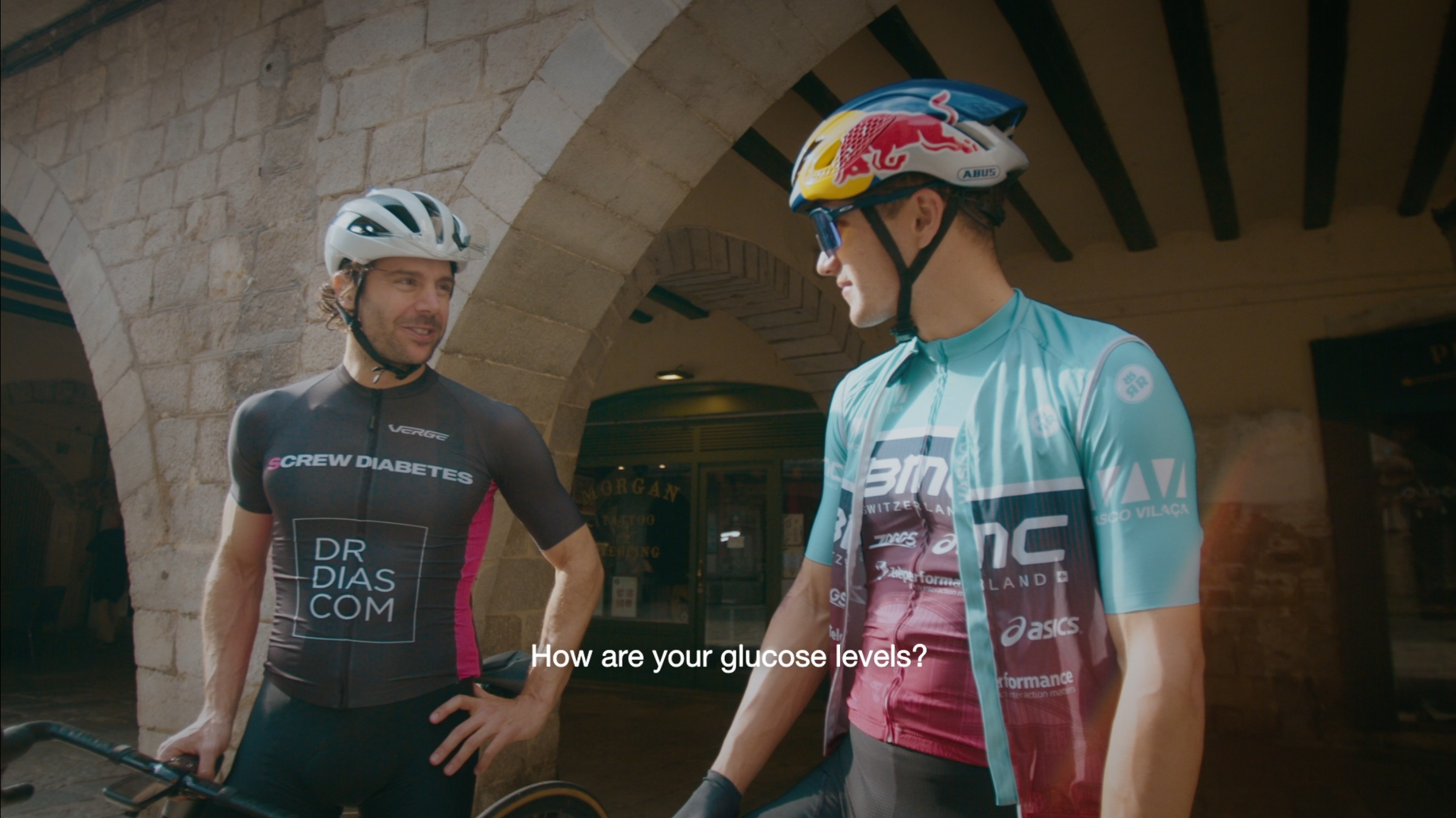 Pedro Dias and Vasco Vilaça in cycling kit, with Vasco's Red Bull helmet visible. The episode subtitle reads: How are your glucose levels?